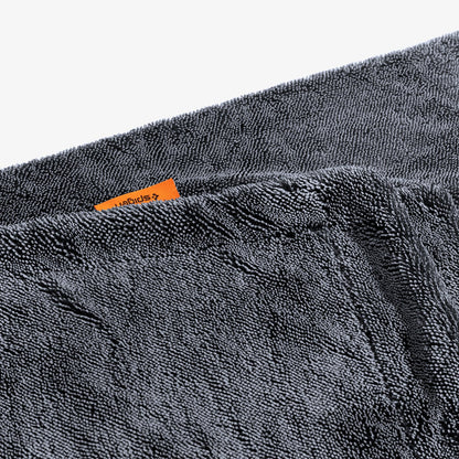 ACP11389 - Close-up of the folded edge of a gray Spigen microfiber car drying towel with an orange brand tag