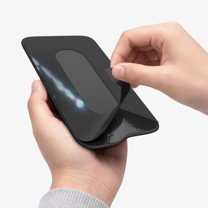 APP11228 - SSD/HDD Holder | LD221 in Black showing hands peeling adhesive backing with flexible fabric pouch stretching open for SSD insertion