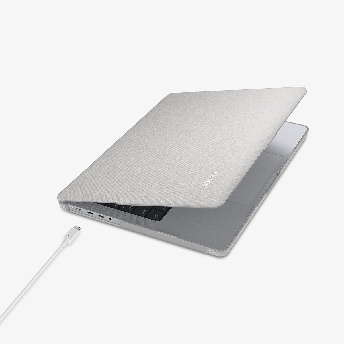 ACS10977 - MacBook Pro 16-inch in Heather Gray showing the top and side with laptop slightly open and charging cable next to port
