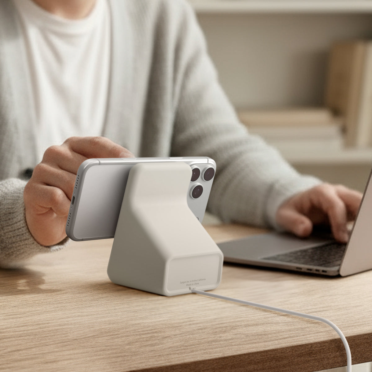 AMP09171 - Magsafe Charger Stand (Mag Fit) in Dune Beige showing a person using their device while attached to the magsafe charger stand