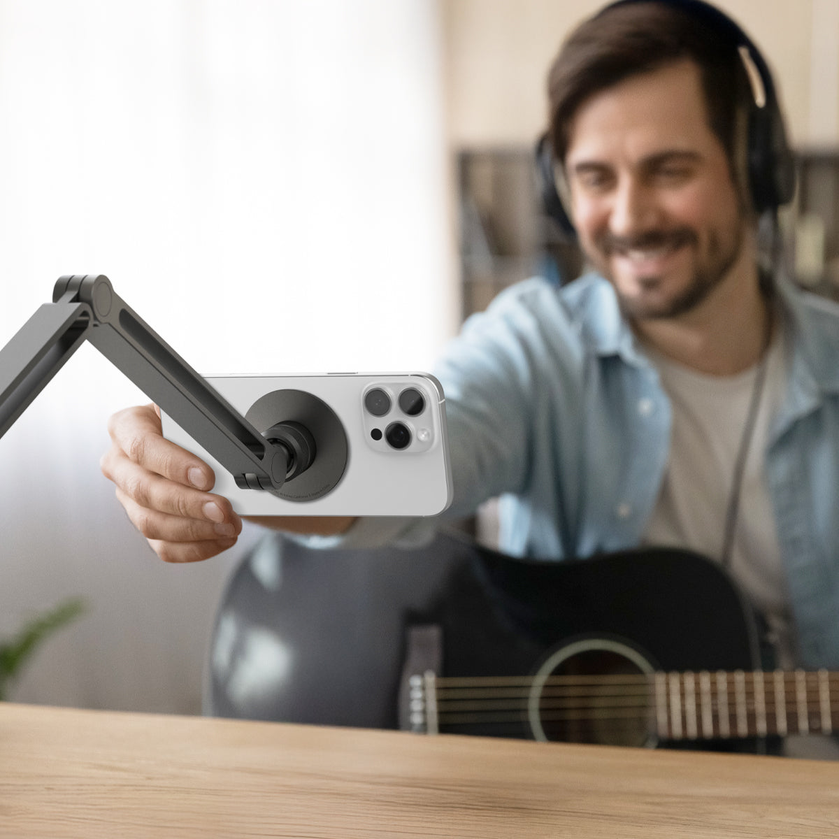 AMP09694 - Phone OneTap Clamp (MagFit) in Space Gray showing a person adjusting the device from the phone holder