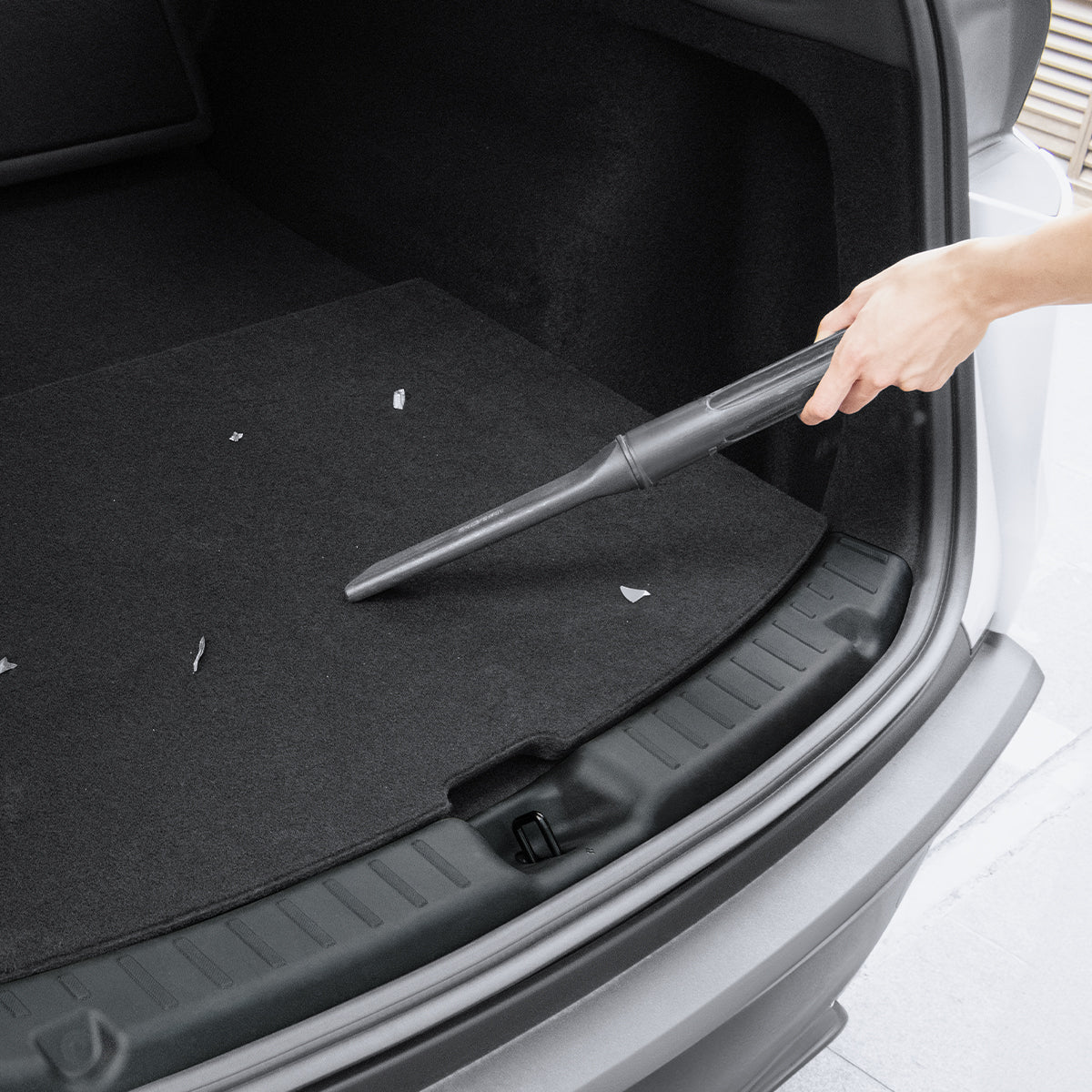 ACP09759 - Tesla Model Y Juniper Trunk Sill Guard | TG100-YJ in black showing someone vacuuming in trunk