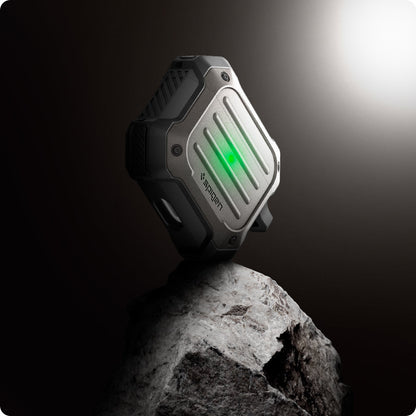 ASD01989 - Apple AirPods 3 Case Tough Armor in gunmetal showing the front and partial side balancing on top of the rock