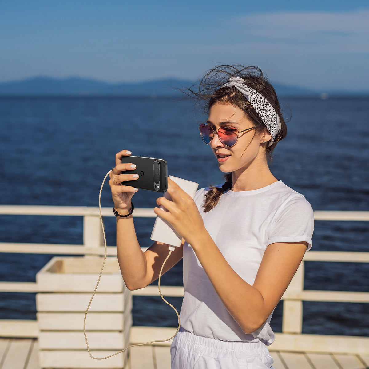 AGL08444 - Pixel 9 Pro Case Optik EZ Fit Lens Protector in Crystal Clear showing a woman holding the device with the installed lens protector