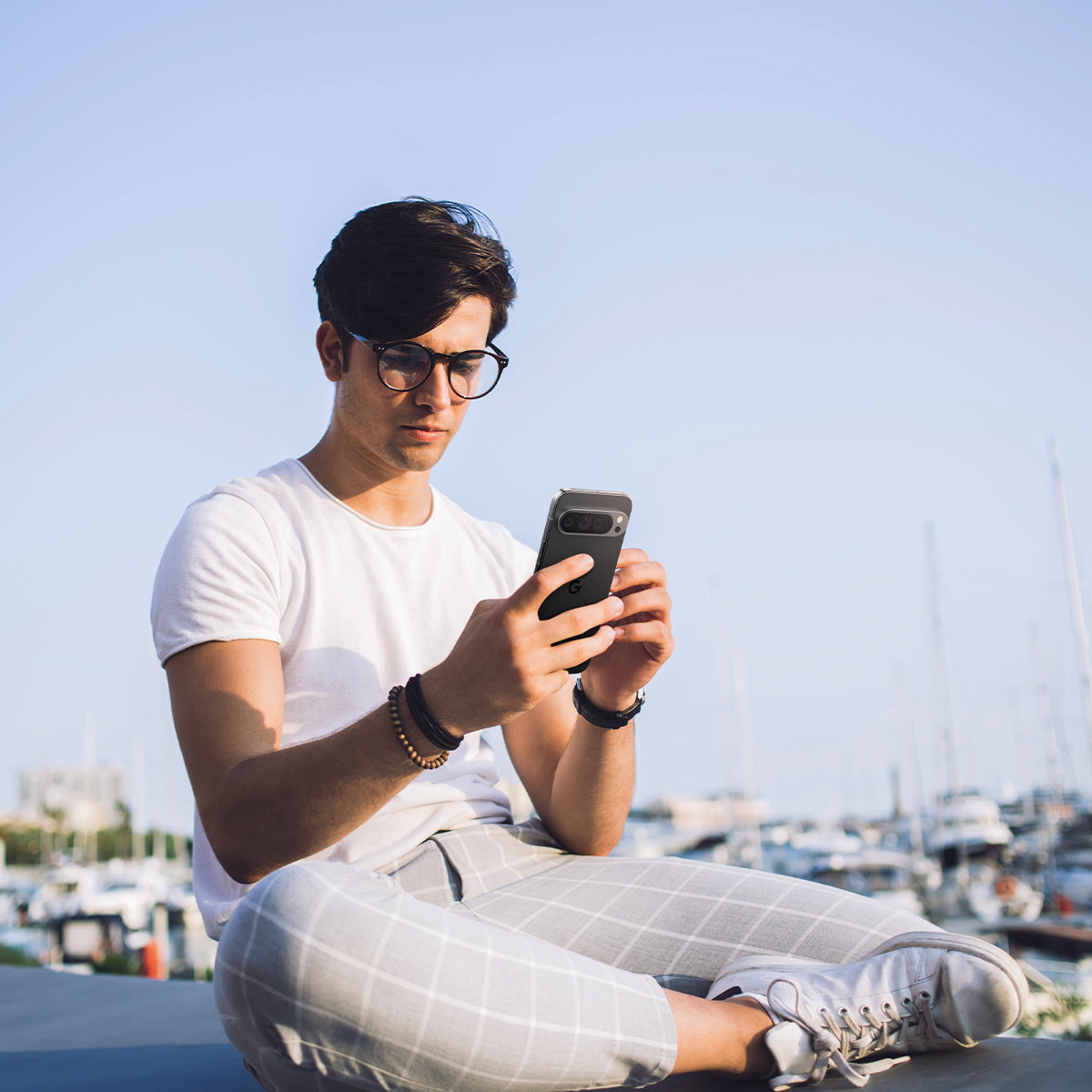 AGL08444 - Pixel 9 Pro Case Optik EZ Fit Lens Protector in Crystal Clear showing a man holding the device with the installed lens protector