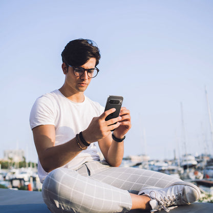 AGL08444 - Pixel 9 Pro Case Optik EZ Fit Lens Protector in Crystal Clear showing a man holding the device with the installed lens protector